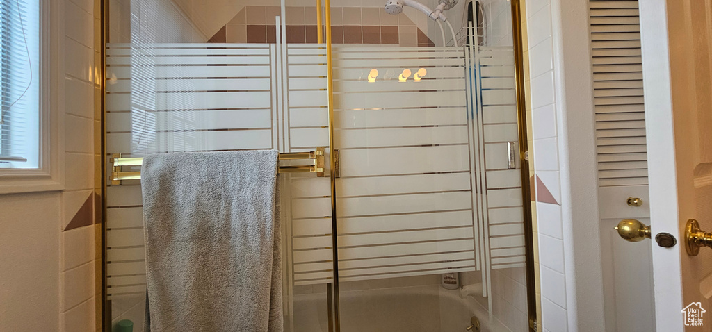 Full bathroom with shower / bath combination with glass door and radiator heating unit