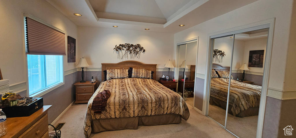 Bedroom with multiple closets, light carpet, and recessed lighting