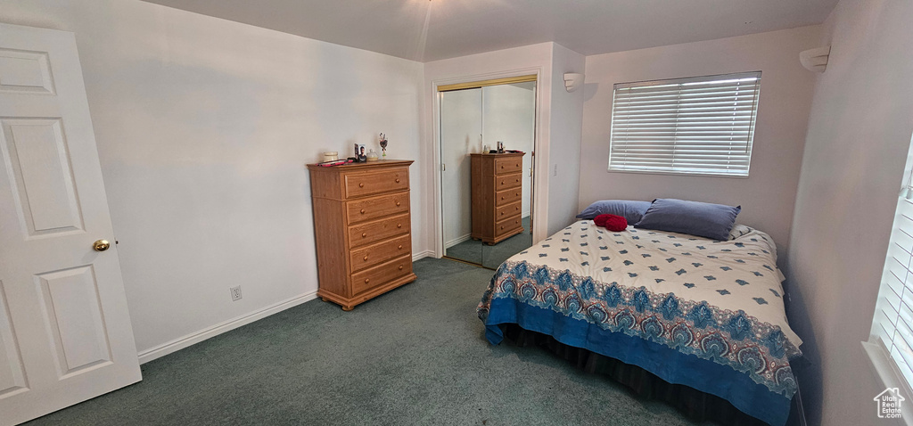 Bedroom with carpet floors, baseboards, and a closet