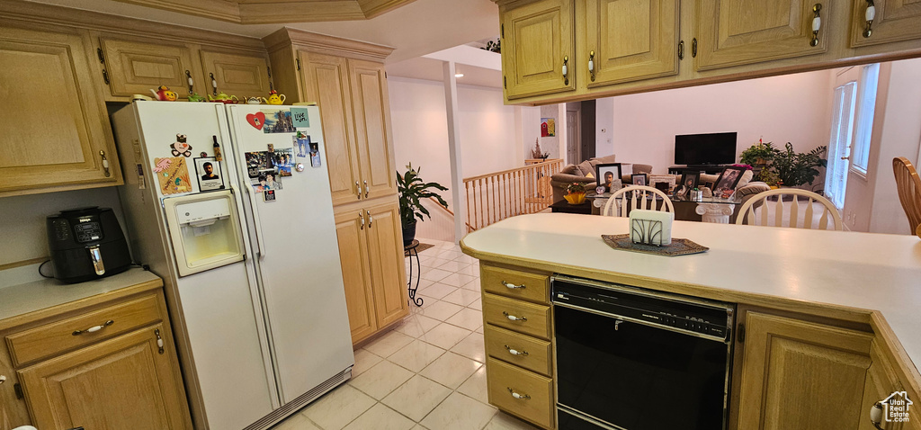 Kitchen with white refrigerator with ice dispenser, dishwasher, light countertops, light tile patterned floors, and crown molding