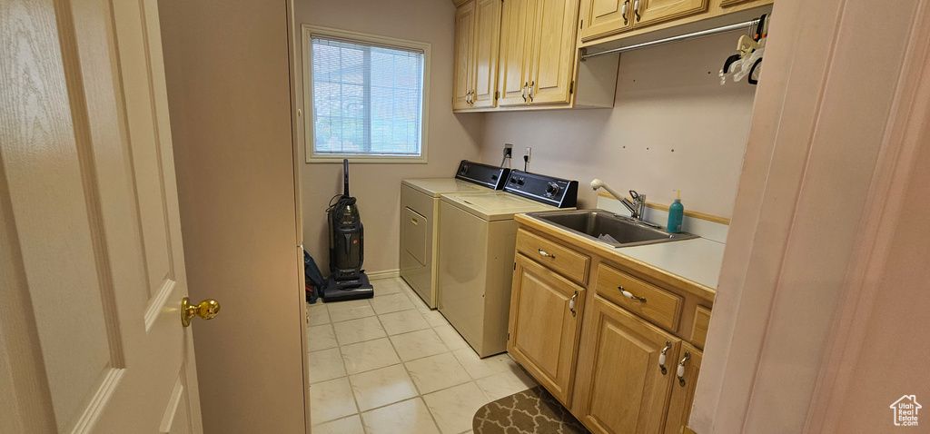 Laundry room featuring cabinet space, washer and dryer, and light tile patterned floors