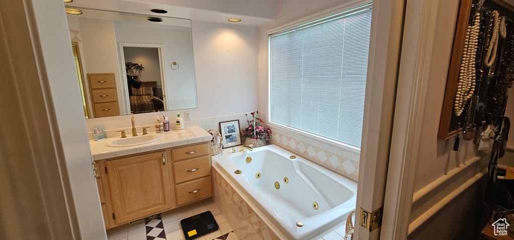 Full bath featuring a whirlpool tub, vanity, and tile patterned floors