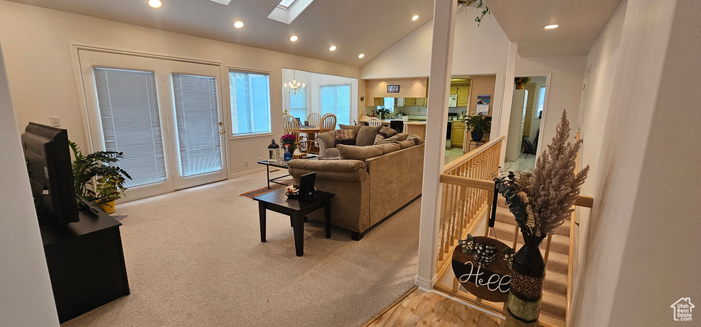 Carpeted living area with a skylight, recessed lighting, and lofted ceiling
