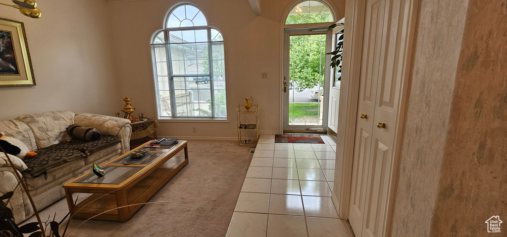 Living room with healthy amount of natural light, light colored carpet, and light tile patterned floors