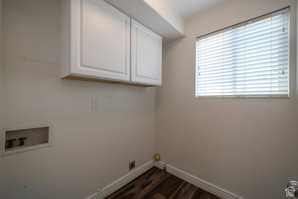 Laundry area with cabinet space, dark wood-type flooring, hookup for a washing machine, baseboards, and electric dryer hookup