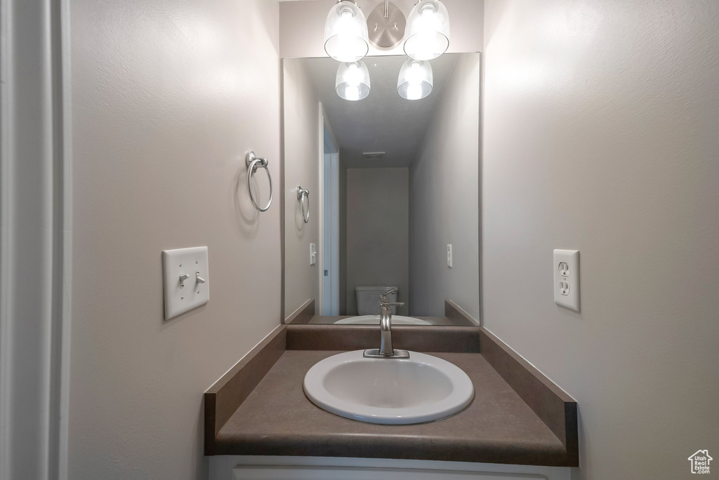 Bathroom with a chandelier and vanity