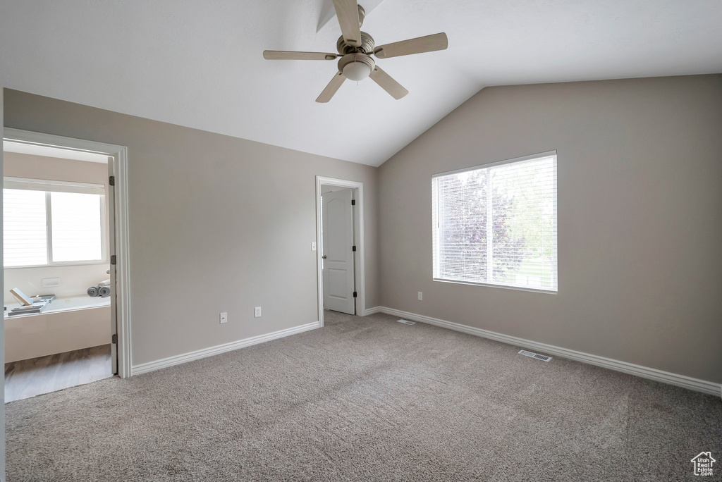 Unfurnished bedroom featuring carpet flooring, vaulted ceiling, baseboards, and ceiling fan