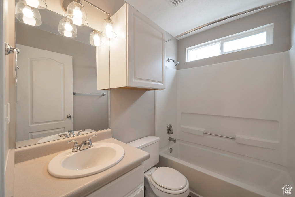 Full bath with toilet, vanity, and bathing tub / shower combination