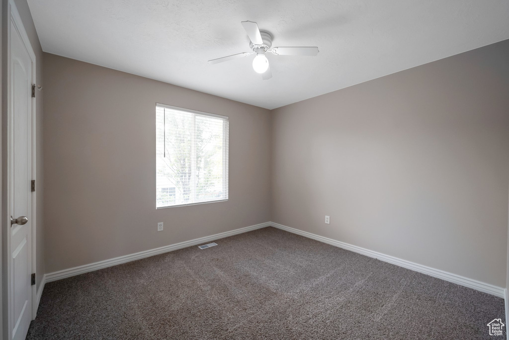 Empty room with carpet, ceiling fan, and baseboards