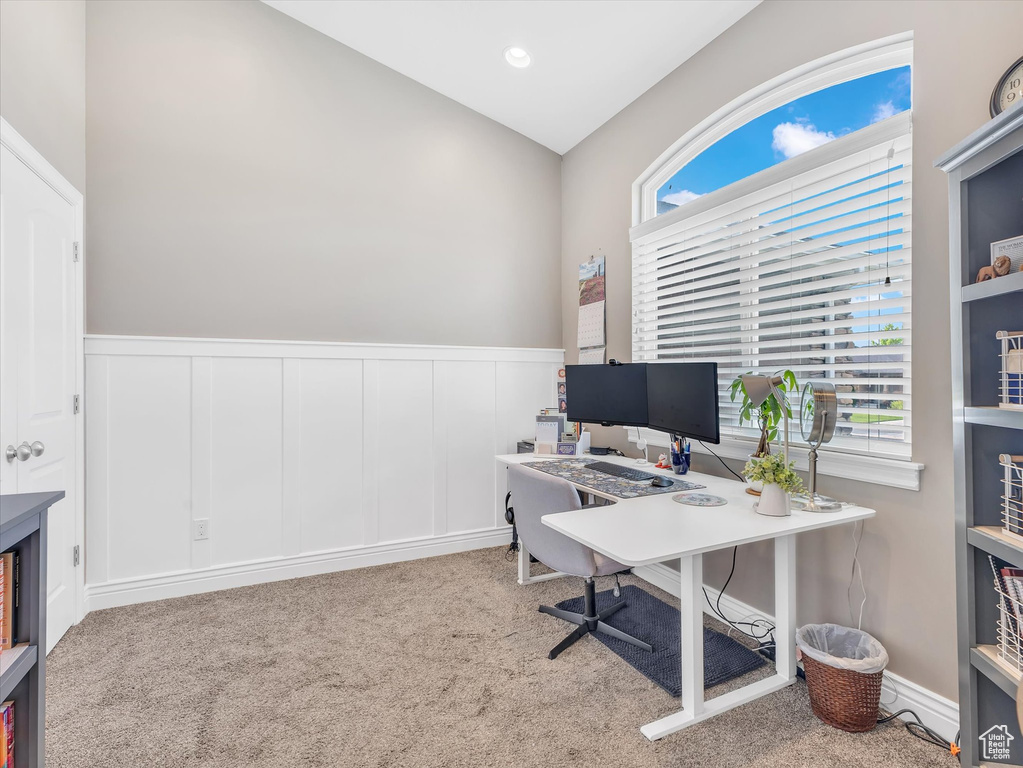 Office area with carpet floors, lofted ceiling, a wainscoted wall, and a decorative wall