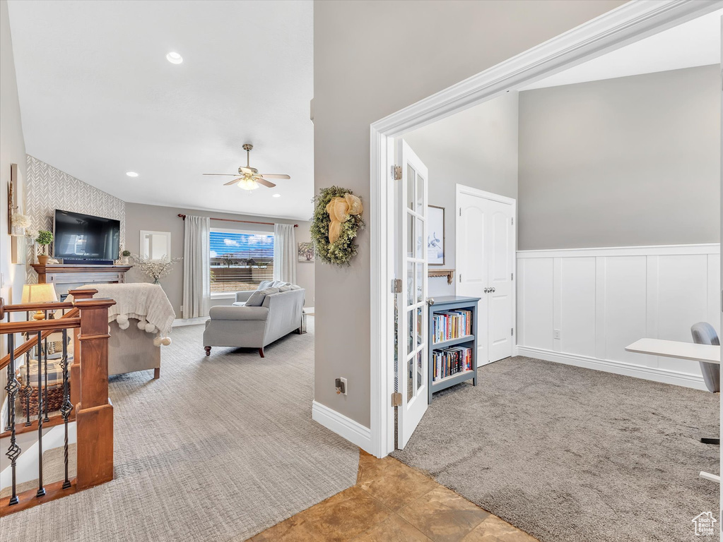 Living area with a ceiling fan, carpet flooring, a wainscoted wall, and recessed lighting