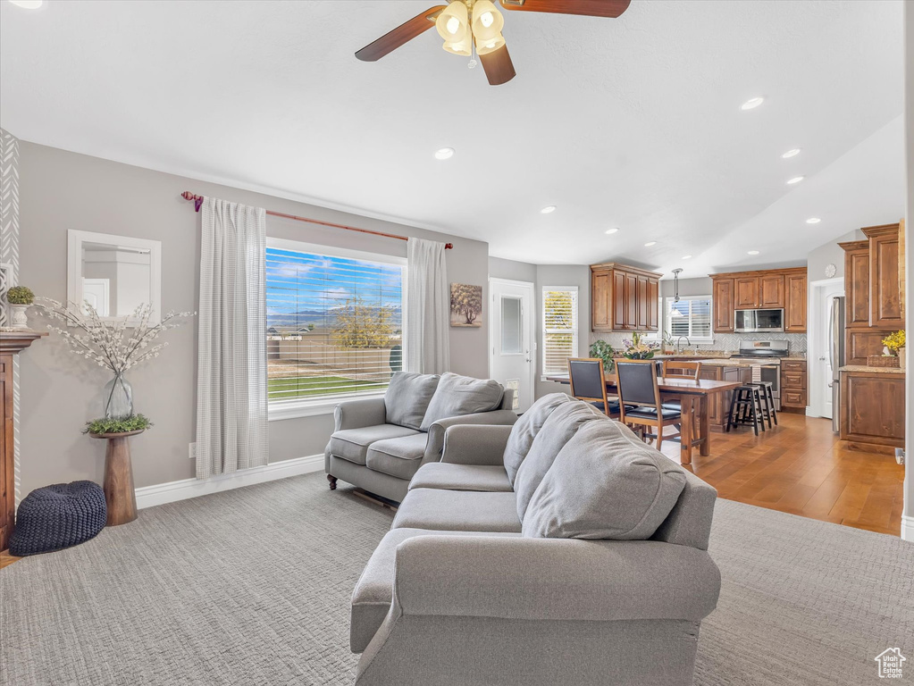 Living room featuring ceiling fan, recessed lighting, baseboards, and light wood finished floors