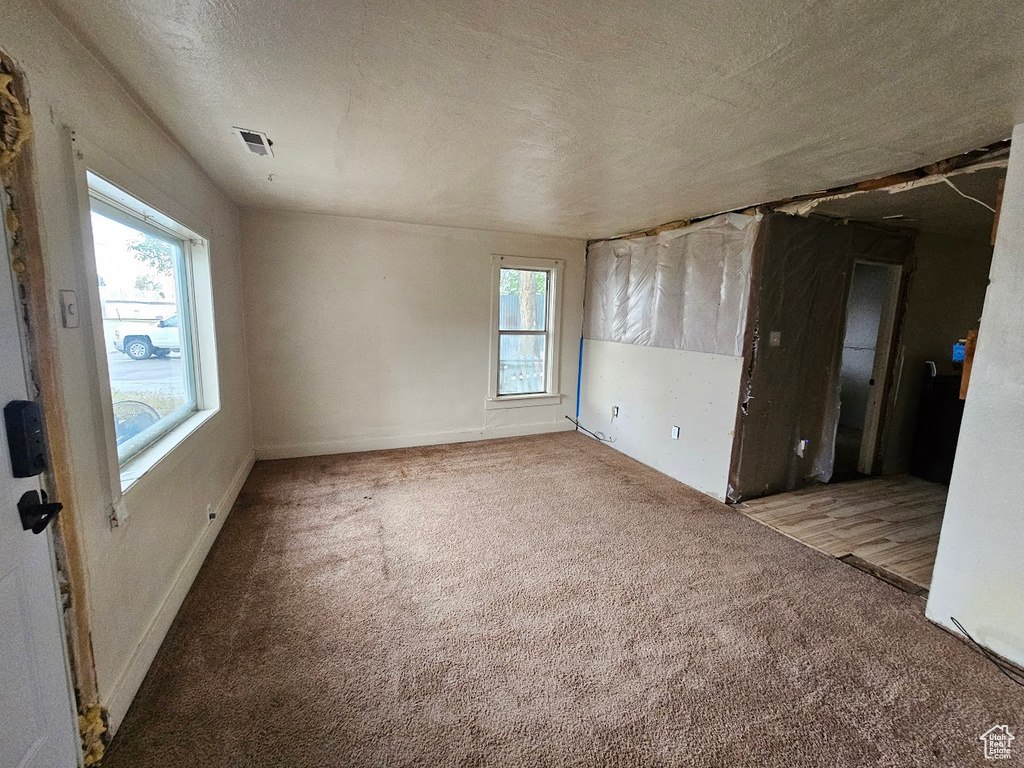 Carpeted empty room featuring a textured ceiling