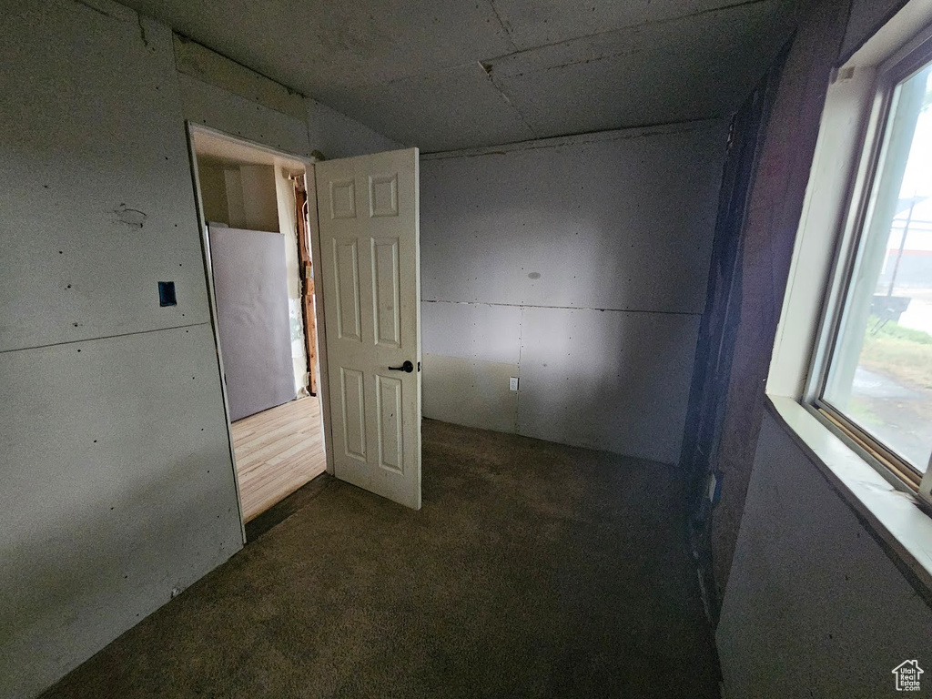 Empty room featuring dark colored carpet