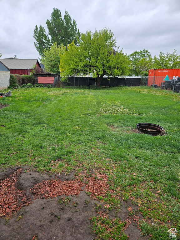 View of yard featuring a fire pit and fence