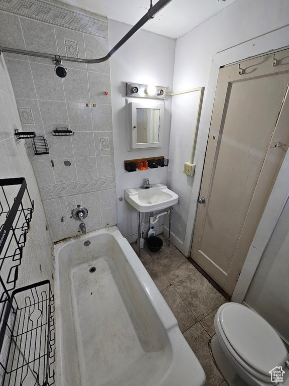 Bathroom featuring tile patterned floors, toilet, and bathtub / shower combination