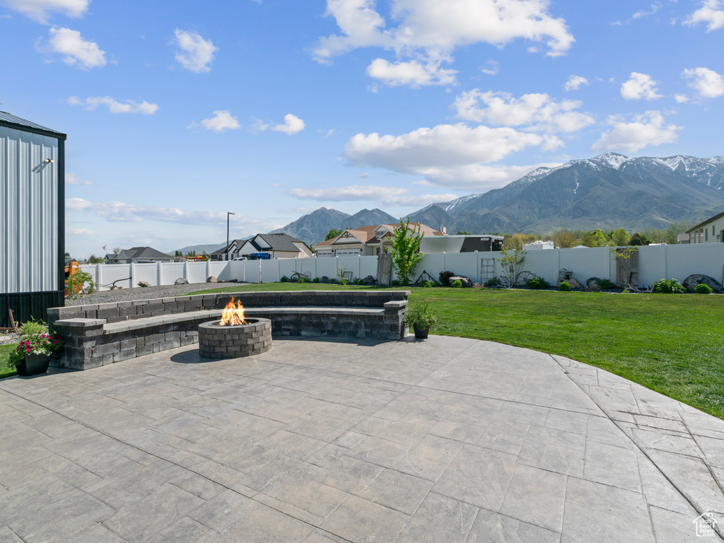 View of patio / terrace with a fire pit, a mountain view, and a residential view