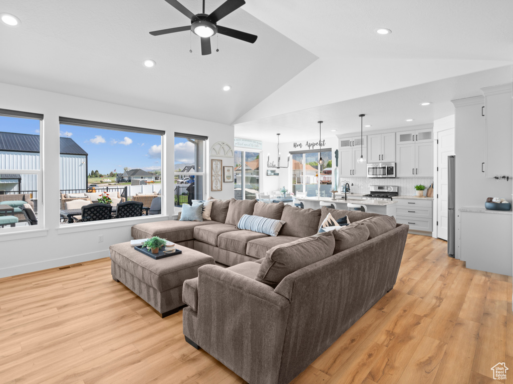 Living area featuring ceiling fan, light wood finished floors, recessed lighting, and high vaulted ceiling
