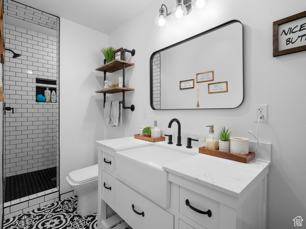 Full bath featuring a shower stall, toilet, vanity, and tile patterned flooring