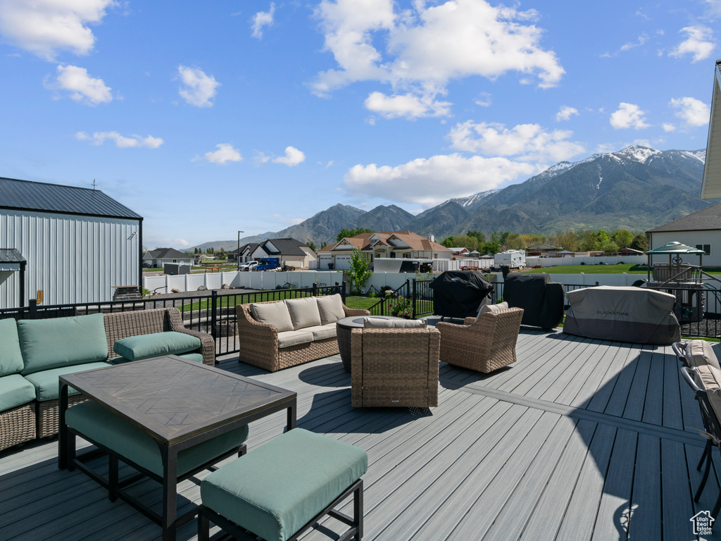 Wooden deck with an outdoor hangout area, a mountain view, and a residential view