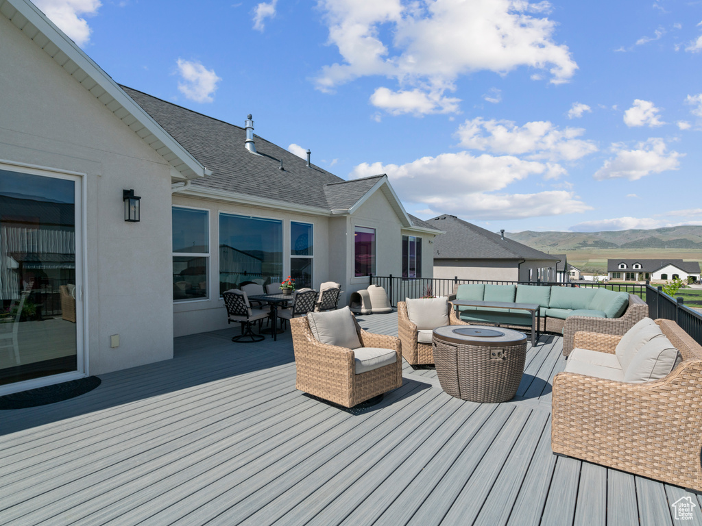 Wooden deck featuring an outdoor hangout area, a mountain view, and outdoor dining space
