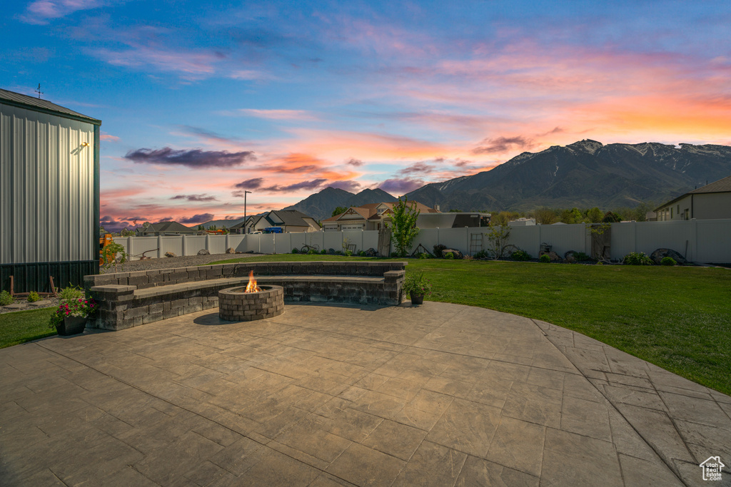 Patio terrace at dusk with a fire pit and a mountain view