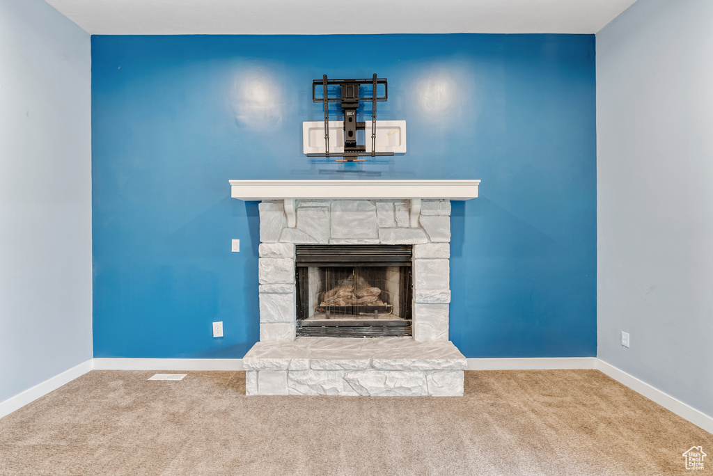 Unfurnished living room featuring baseboards, a fireplace, and carpet flooring