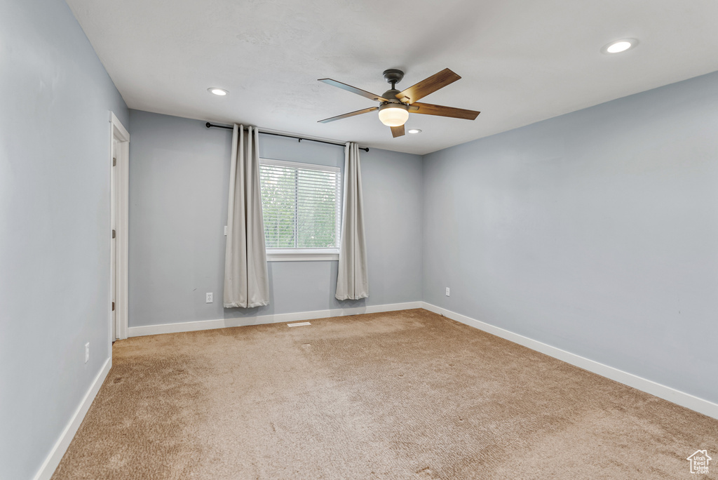 Carpeted spare room featuring baseboards, recessed lighting, and ceiling fan
