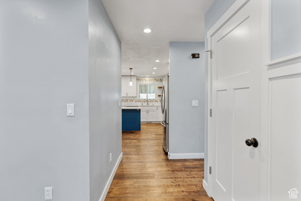 Hallway featuring wood finished floors, recessed lighting, and baseboards