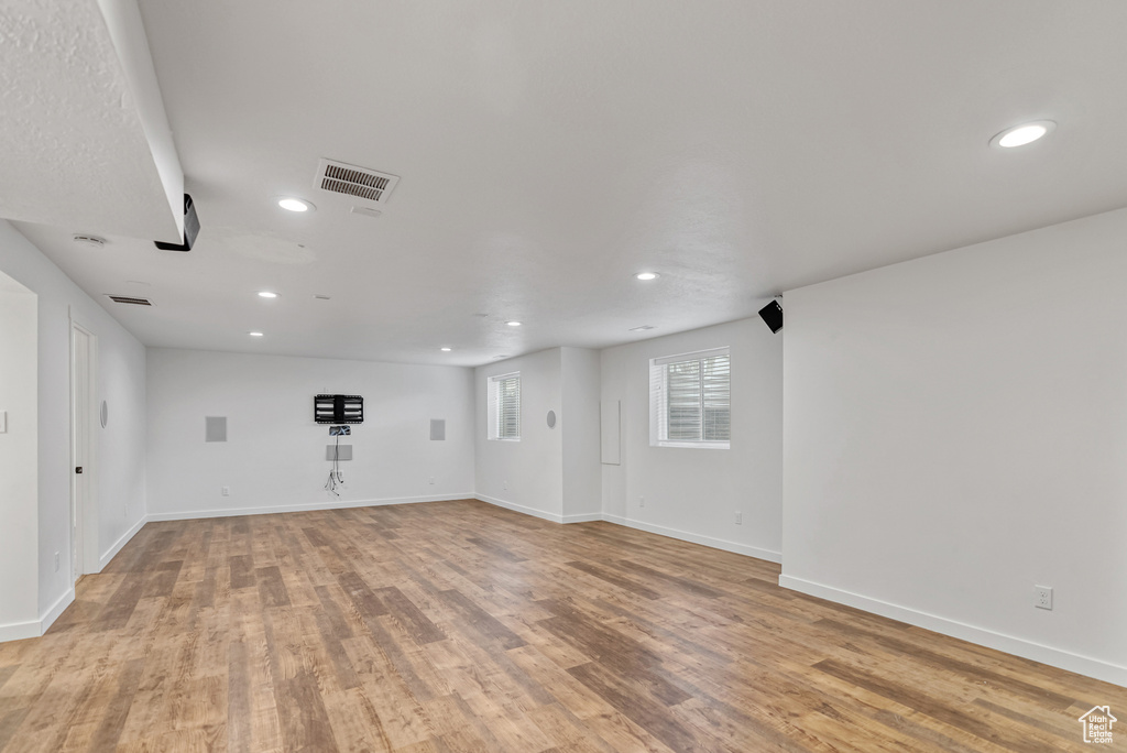 Unfurnished room with recessed lighting, visible vents, light wood-style flooring, and baseboards