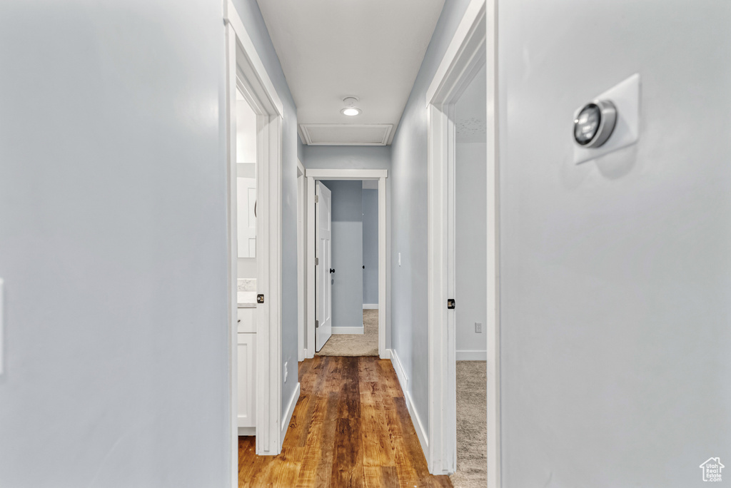 Corridor featuring baseboards, recessed lighting, wood finished floors, and attic access