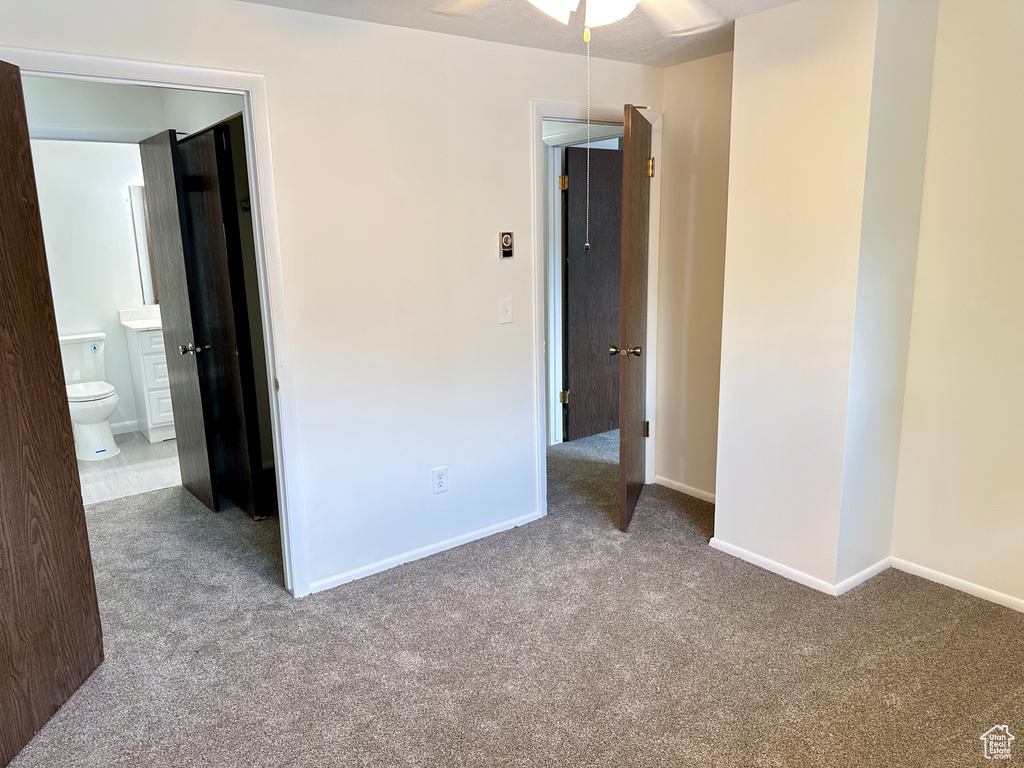 Unfurnished bedroom featuring carpet flooring, baseboards, and ensuite bathroom