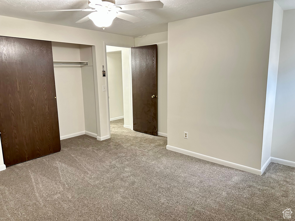 Unfurnished bedroom featuring carpet flooring, baseboards, and a closet