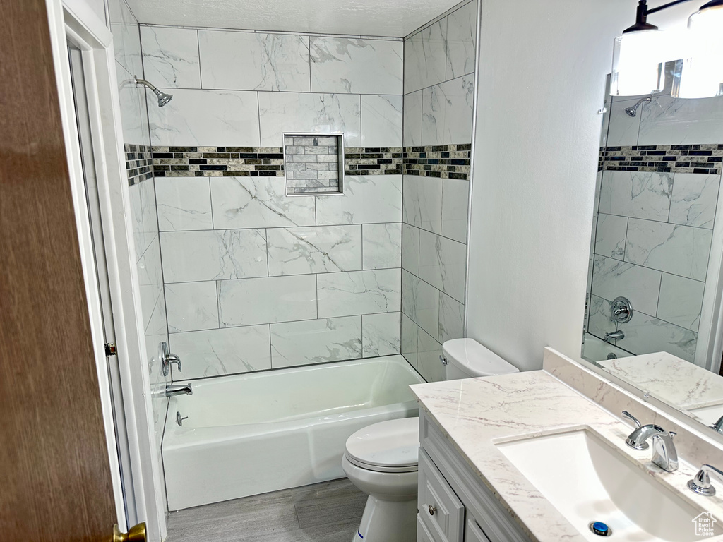 Full bath featuring toilet, shower / washtub combination, vanity, and wood finished floors