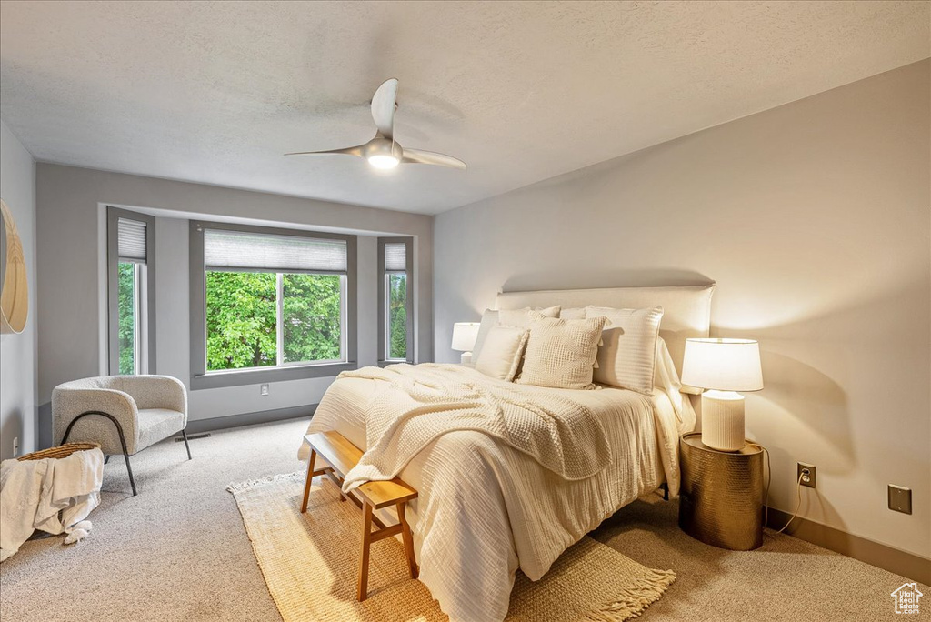 Bedroom with carpet, baseboards, ceiling fan, and a textured ceiling
