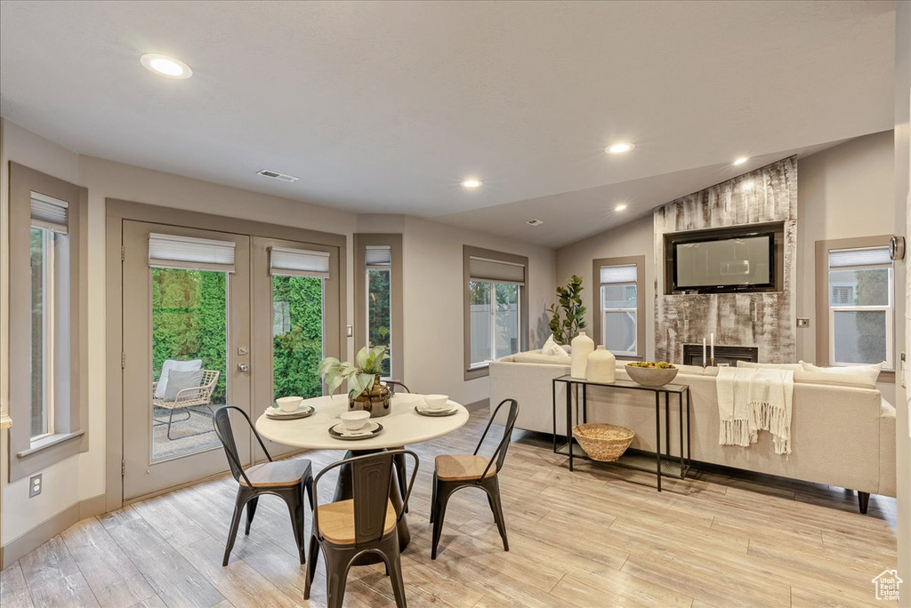 Dining room featuring light wood-type flooring, a fireplace, french doors, recessed lighting, and baseboards