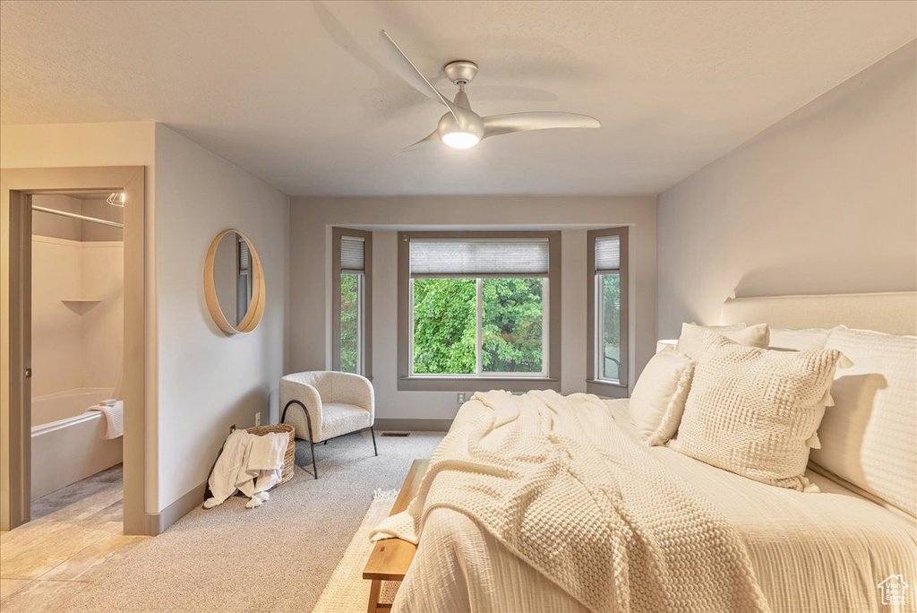 Bedroom with light colored carpet, baseboards, and ceiling fan