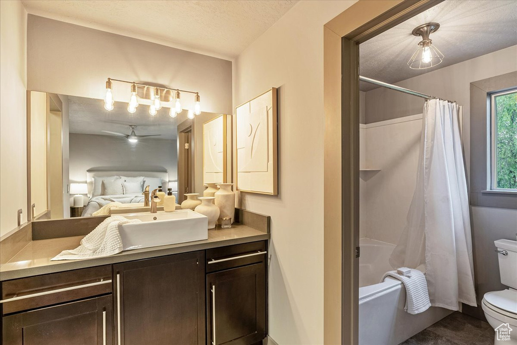 Full bath featuring toilet, vanity, and shower / bath combo with shower curtain