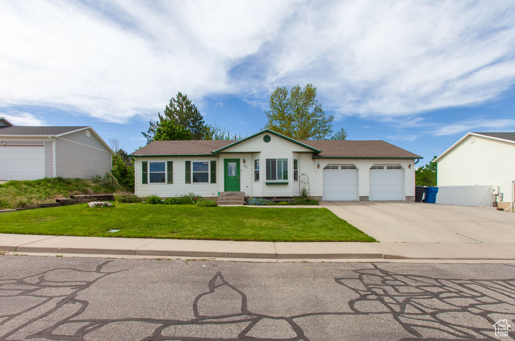 Single story home with an attached garage, concrete driveway, and roof with shingles