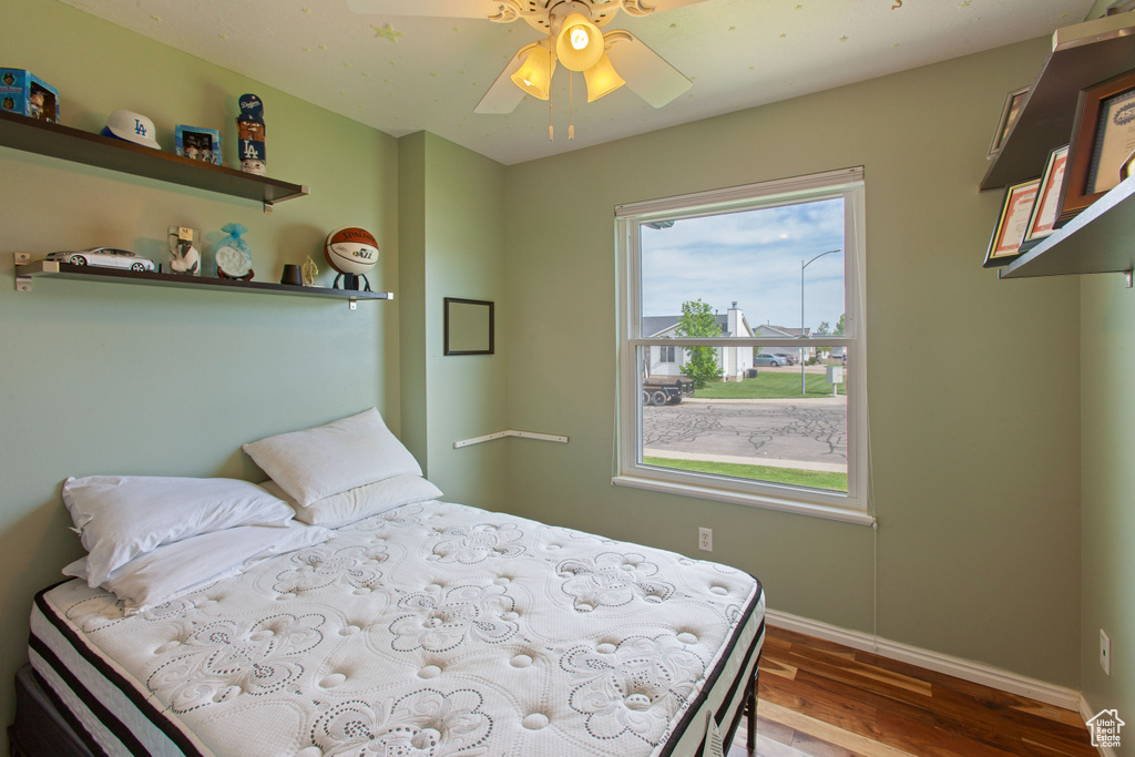 Bedroom with wood finished floors, baseboards, and a ceiling fan