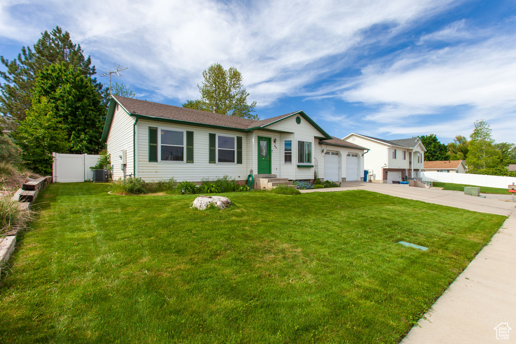 Single story home with driveway, a garage, and central AC