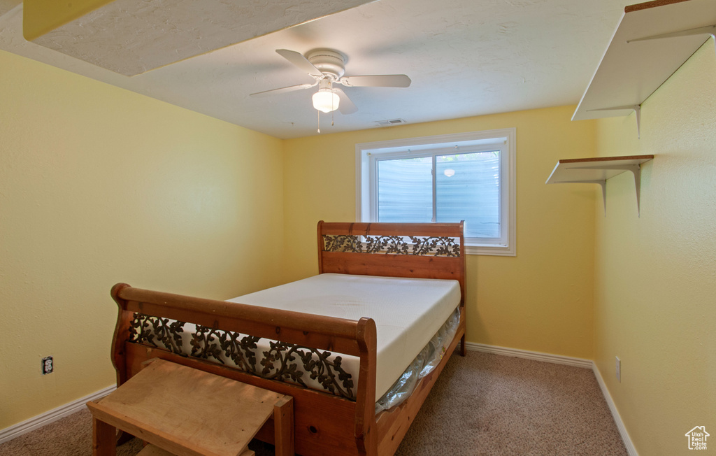 Carpeted bedroom with baseboards and a ceiling fan