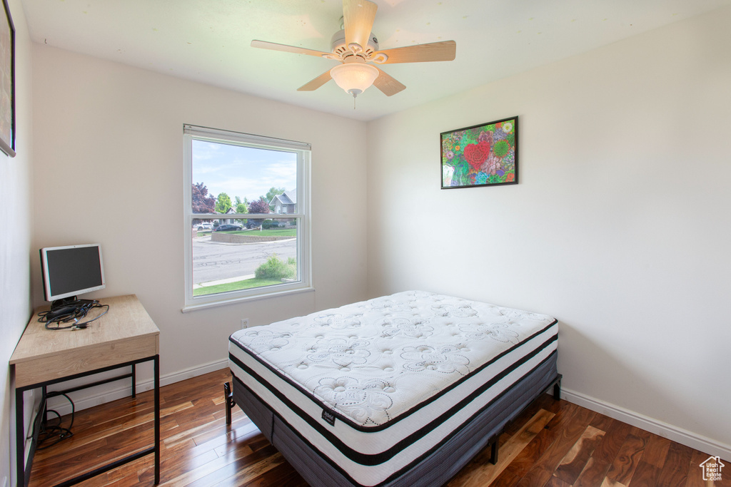 Bedroom featuring baseboards, dark wood-type flooring, and a ceiling fan