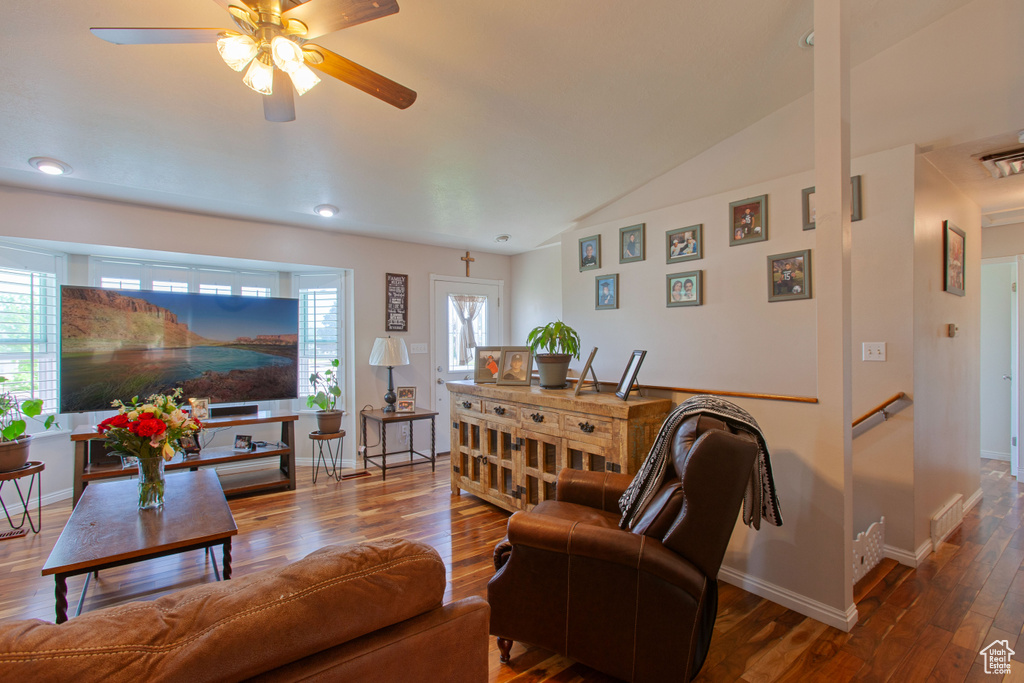 Living room with wood finished floors, ceiling fan, baseboards, lofted ceiling, and recessed lighting