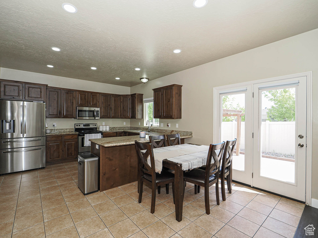 Kitchen featuring appliances with stainless steel finishes, recessed lighting, dark brown cabinets, a sink, and light tile patterned floors