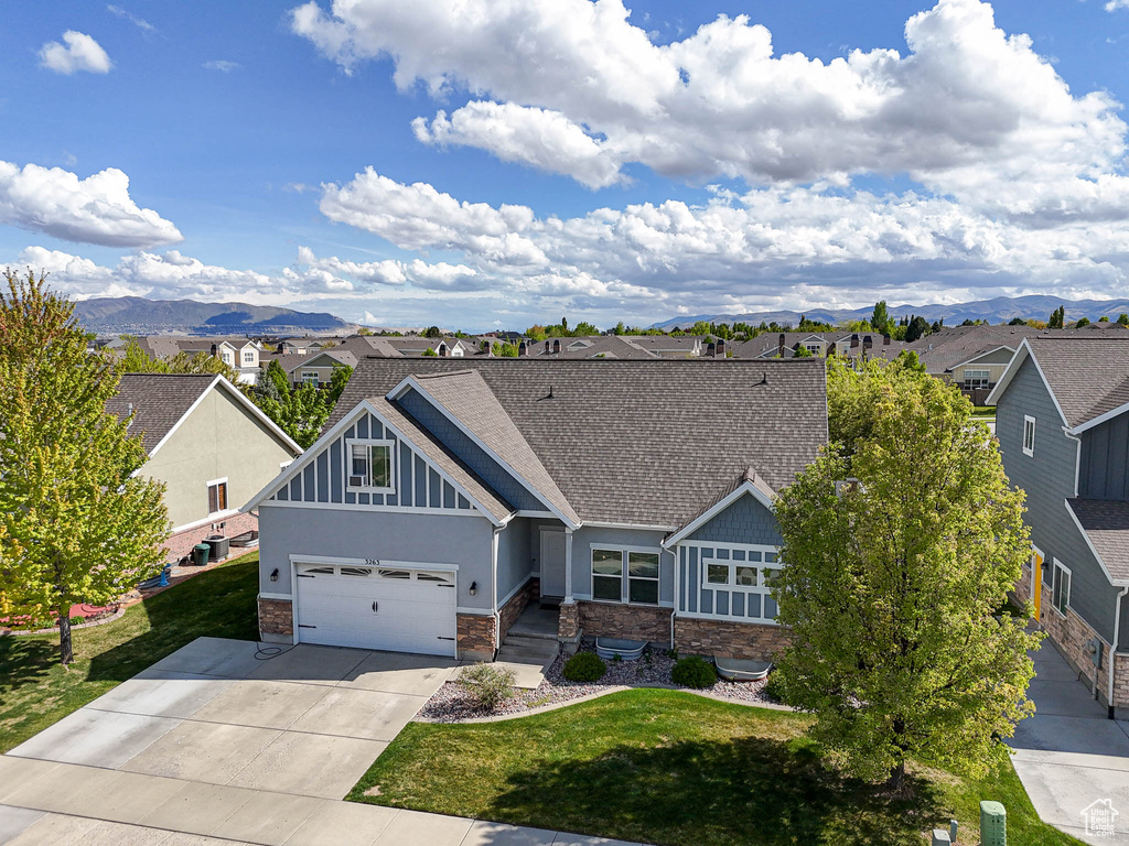 Craftsman-style house with a residential view, driveway, a shingled roof, and a mountain view