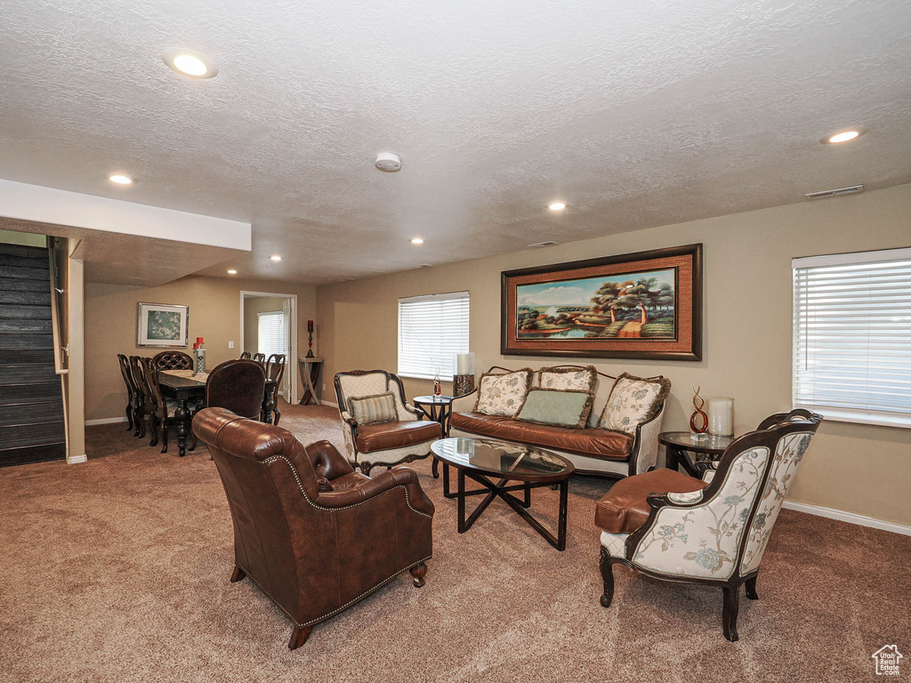 Carpeted living room with recessed lighting, a textured ceiling, stairway, and baseboards