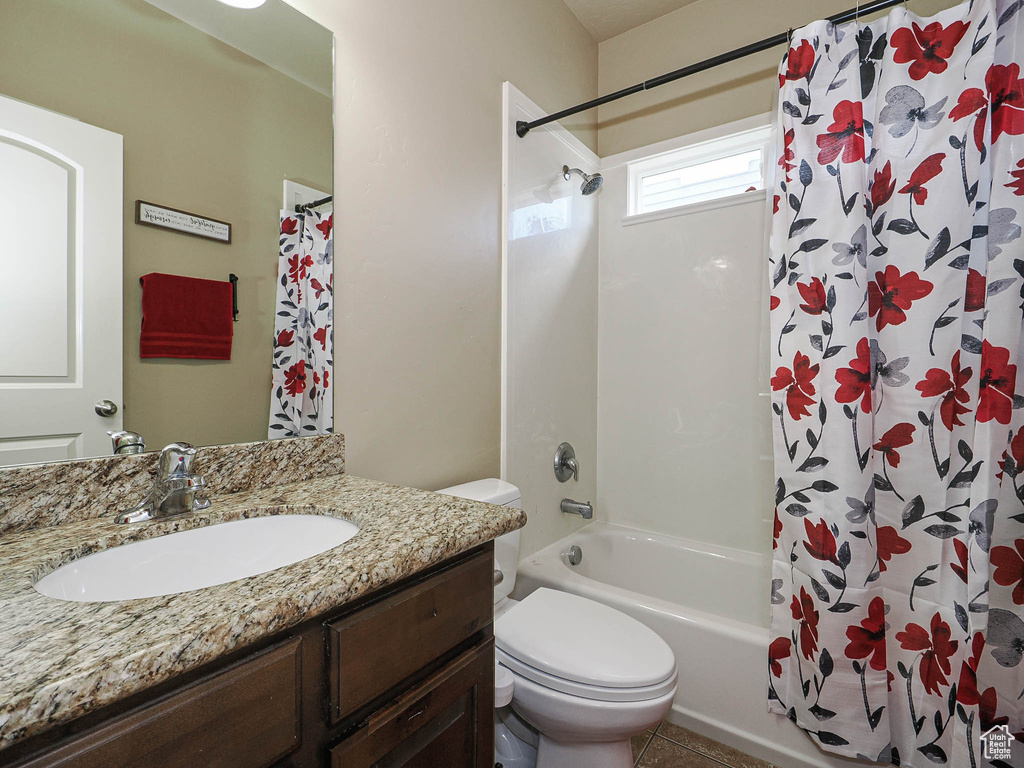Bathroom with toilet, shower / bath combo, and vanity