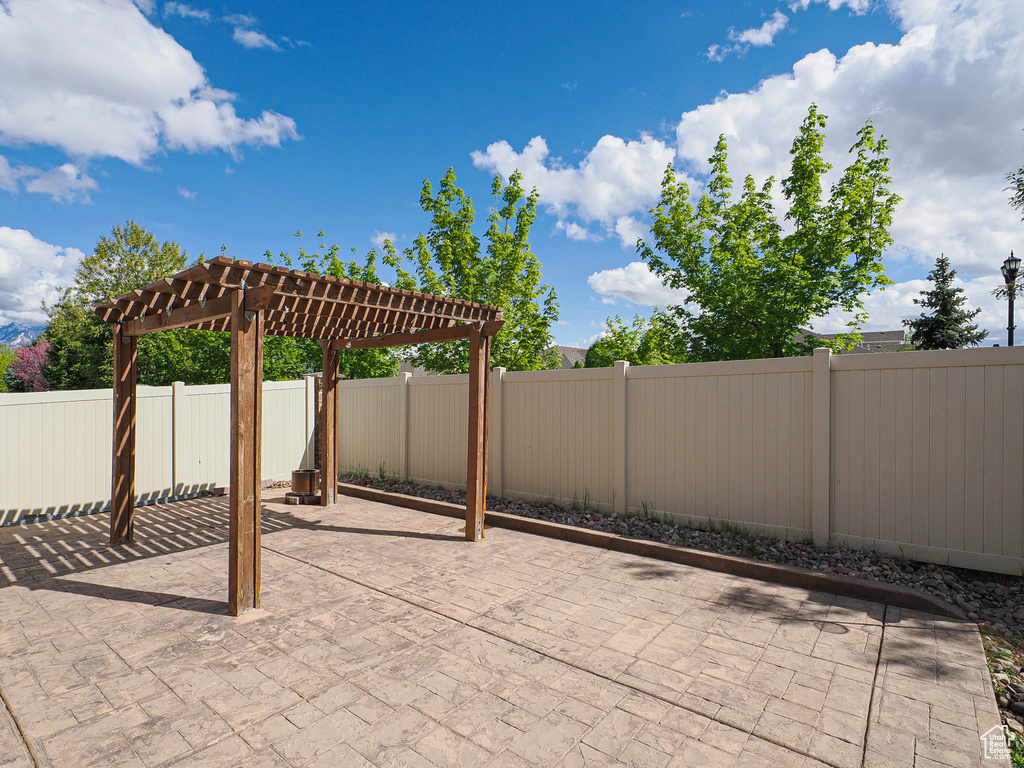 View of patio with a pergola and a fenced backyard