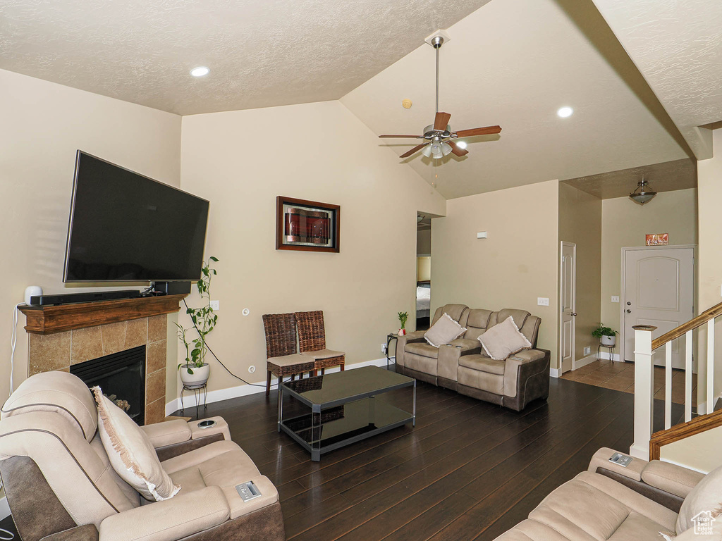 Living room with a ceiling fan, baseboards, wood finished floors, stairway, and a textured ceiling